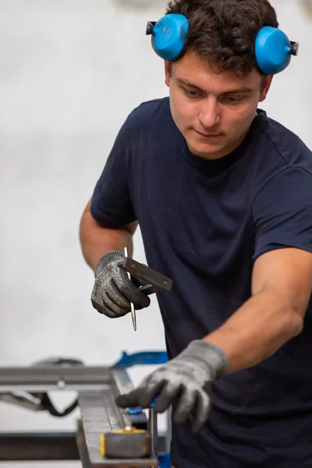 Photo d'un homme métallier entrain de tracer avec des outils adapté